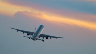 Airplane taking off in the sunset.