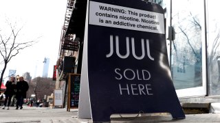 A sign advertising Juul brand vaping products is seen outside a shop in New York City, February 6, 2019.