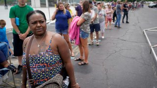 A woman waits in a line outside a temporary unemployment office in Frankfort, Kentucky in June.