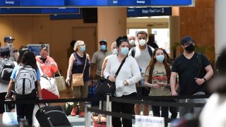 Passengers wearing face masks arrive at Orlando International Airport.
