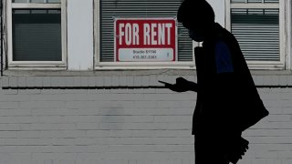 In this Oct. 20, 2020 file photo, a man walks in front of a For Rent sign in a window of a residential property in San Francisco