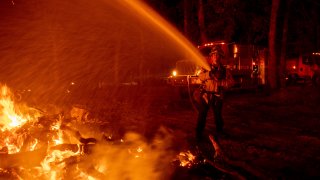 Firefighter Ron Burias battles the Fawn Fire as it spreads