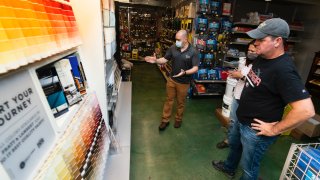 Billy Wommack, purchasing director at the W.S. Jenks & Sons hardware, left, works with customer Tim Wood, right, picking a paint color