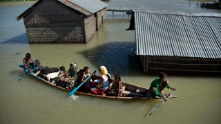 FILE - In this July 31, 2016, file photo, a flood-affected family with their goats travel on a boat in the Morigaon district, east of Gauhati, northeastern Assam state, India.