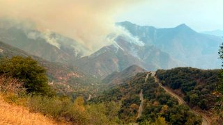 In this Sunday, Sept. 12, 2021 photo released by the KNP Complex Fire Incident Command, smoke plumes rise from the Paradise Fire in Sequoia National Park, Calif. In the southern Sierra Nevada, two fires ignited by lightning are burning in Sequoia National Park.