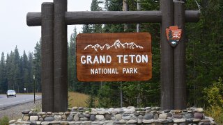 A National Park Service sign welcomes visitors to the Grand Teton National Park in Wyoming. (Photo by Robert Alexander/Getty Images)