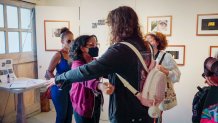 two teen girls hug in an art gallery