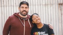 a man and a teen girl pose for a picture with smiles on their faces