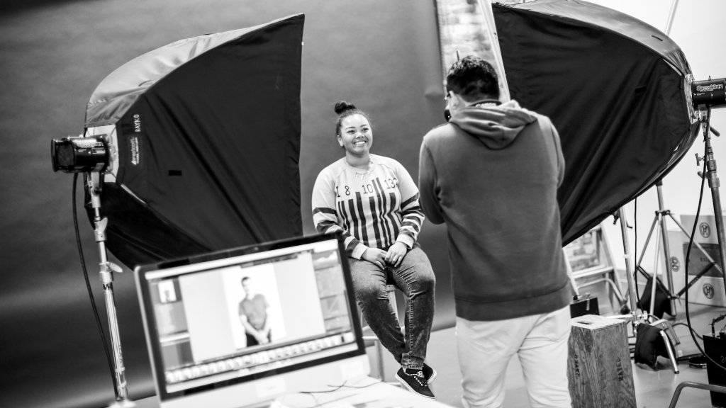 a teen photographs another teen in a portrait studio