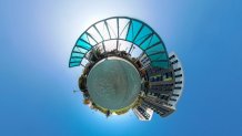 tiny planet photo of an outdoor gazebo with a mid-rise building next to it