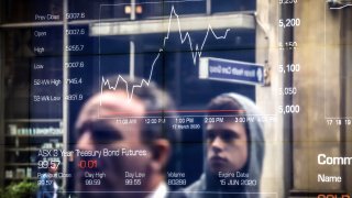 People are reflected in a window at the Australian Securities Exchange in Sydney on March 17, 2020.