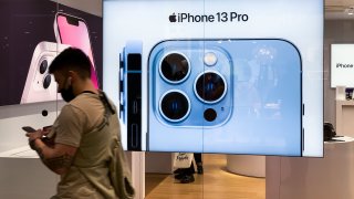 A man passes by iPhone 13 Pro ad on an Apple storefront in Krakow, Poland on September 30, 2021.