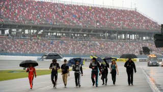 Team members walking through pit row