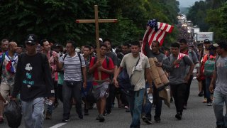 Migrants walk along the highway