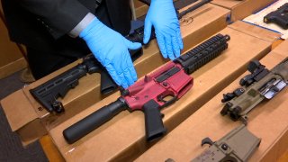 Sgt. Matthew Elseth with "ghost guns" on display at the headquarters of the San Francisco Police Department