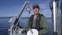 Brant Allen, Field Lab Director for the Tahoe Environmental Research Center holds a "secchi disc" which is dropped into the water and used to measure water clarity.