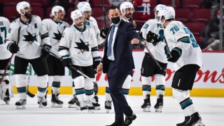 Head coach of the San Jose Sharks Bob Boughner fist pumps with Jonathan Dahlen #76 over their victory against the Montreal Canadiens at Centre Bell on October 19, 2021 in Montreal, Canada. The San Jose Sharks defeated the Montreal Canadiens 5-0.