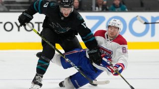 Skating for control of the puck Nick Bonino #13 of the San Jose Sharks collides with Artturi Lehkonen #62 of the Montreal Canadiens during the third period at SAP Center on October 28, 2021 in San Jose, California. Montreal won the game 4-0.