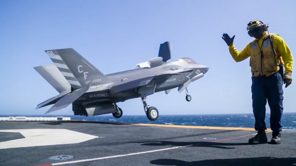 A fighter jet launches from the deck of a Navy ship.