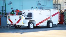 A shipboard firefighting truck parked on the flight deck of a ship