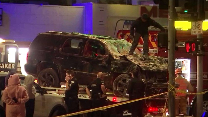 A damaged SUV is towed from the scene of a crash in Van Nuys.