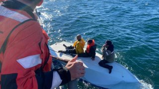 Coast Guard Station Bodega Bay boat crew members rescue three fishermen from a capsized boat near Tomales Bay.