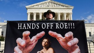 A man holds a sign supporting Roe vs. Wade in front of the US Supreme Court Building in Washington, DC on November 30, 2021.