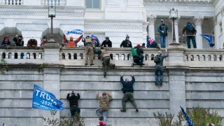 FILE – Violent insurrectionists loyal to President Donald Trump scale the west wall of the the U.S. Capitol in Washington, Jan. 6, 2021.