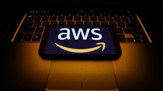 Amazon Web Services logo displayed on a phone screen and a laptop keyboard are seen in this illustration photo taken in Krakow, Poland on December 1, 2021. (Photo by Jakub Porzycki/NurPhoto via Getty Images)
