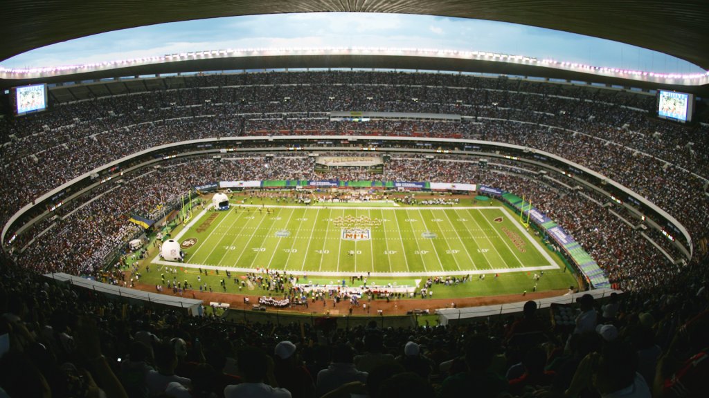 100,000 people sit in a stadium surrounding a football gridiron