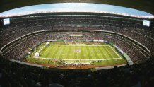 100,000 people sit in a stadium surrounding a football gridiron