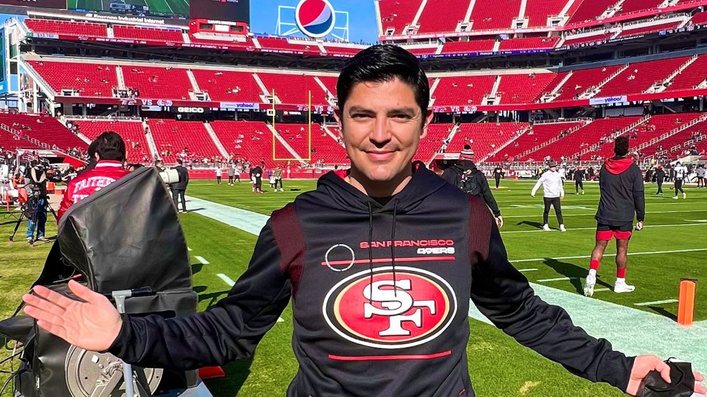 El atleta de telemundo 48 Carlos Eustis se para en el campo del Levi's Stadium con la sudadera con capucha de los 49ers