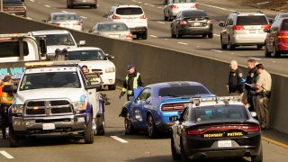 A police officer riding a motorcycle was killed after being struck by a man, driving the blue car, center, the wrong way on southbound Highway 99 in Sacramento, Calif., Friday, Jan. 21, 2022.