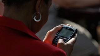 A woman works on her Blackberry in 2008