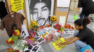 A woman leaves a sign at a make-shift memorial for Oscar Grant after the sentencing of former Bay Area Rapid Transit police officer Johannes Mehserle