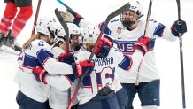 United States players celebrate a goal scored against Switzerland, Feb. 6, 2022, in Beijing. Team USA kept their winning streak strong, routing Switzerland 7 to 0.