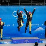 Francesco Friedrich and Thorsten Margis, of Germany, celebrate winning the gold medal in the 2-man bobsleigh at the 2022 Winter Olympics