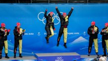 Francesco Friedrich and Thorsten Margis, of Germany, celebrate winning the gold medal in the 2-man bobsleigh at the 2022 Winter Olympics