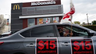 Fast-food workers drive-through to protest for a $15 dollar hourly minimum wage outside a McDonald's restaurant in East Los Angeles