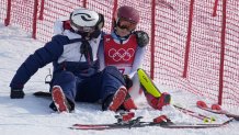 A team member consoles Mikaela Shiffrin, of the United States after she skied out in the first run of the Women's Slalom at the 2022 Winter Olympics, Feb. 9, 2022, in the Yanqing district of Beijing, China.