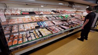 FILE - A man looks at beef in the meat department at Lambert's Rainbow Market, on June 15, 2021, in Westwood, Mass.