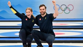 Sweden's Oskar Eriksson and Sweden's Almida de Val (L) celebrate after the mixed doubles bronze medal game of the 2022 Winter Olympics curling competition between Sweden and Britain, at the National Aquatics Centre in Beijing, China on Feb. 8, 2022.