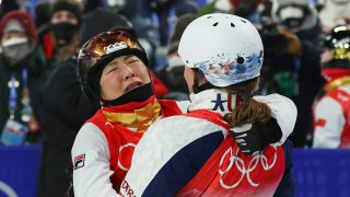 Gold medallist Xu Mengtao of Team China is embraced by Ashley Caldwell of Team United States