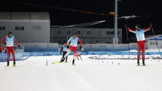 Joergen Graabak of Team Norway celebrates winning the Gold medal as Silver medal winner Jens Luraas Oftebro of Team Norway and Bronze medal winner Akito Watabe of Team Japan cross the finishing line