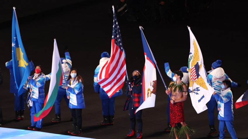 Flag bearers Elana Meyers Taylor of Team USA, center, and Nathan Crumpton of Team American Samoa (second right) walks in the Athletes Parade during the Beijing 2022 Winter Olympics Closing Ceremony on Day 16 of the Beijing 2022 Winter Olympics at Beijing National Stadium on Feb. 20, 2022 in Beijing.