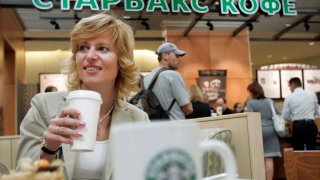 A woman drinks coffee in a Starbucks in a mall in Khimki outside Moscow.