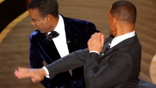 Will Smith, right, hits Chris Rock as Rock spoke on stage during the 94th Academy Awards in Hollywood, Los Angeles, California, March 27, 2022.