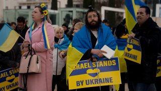 People gather in Habima Square in Tel Aviv, Israel, to watch Ukrainian President Volodymyr Zelenskyy in a video address to the Knesset, Israel's parliament, Sunday, March 20, 2022.