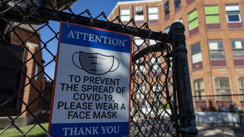 A sign encouraging mask use hangs on a fence before the local school council and the Chicago Teachers Union held a press conference Tuesday, Sept. 28, 2021 outside Jensen Elementary School in Chicago's North Lawndale neighborhood. (Brian Cassella/Chicago Tribune/Tribune News Service via Getty Images)
