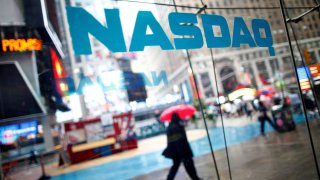 Pedestrians walk past the NASDAQ MarketSite in New York’s Times Square.
